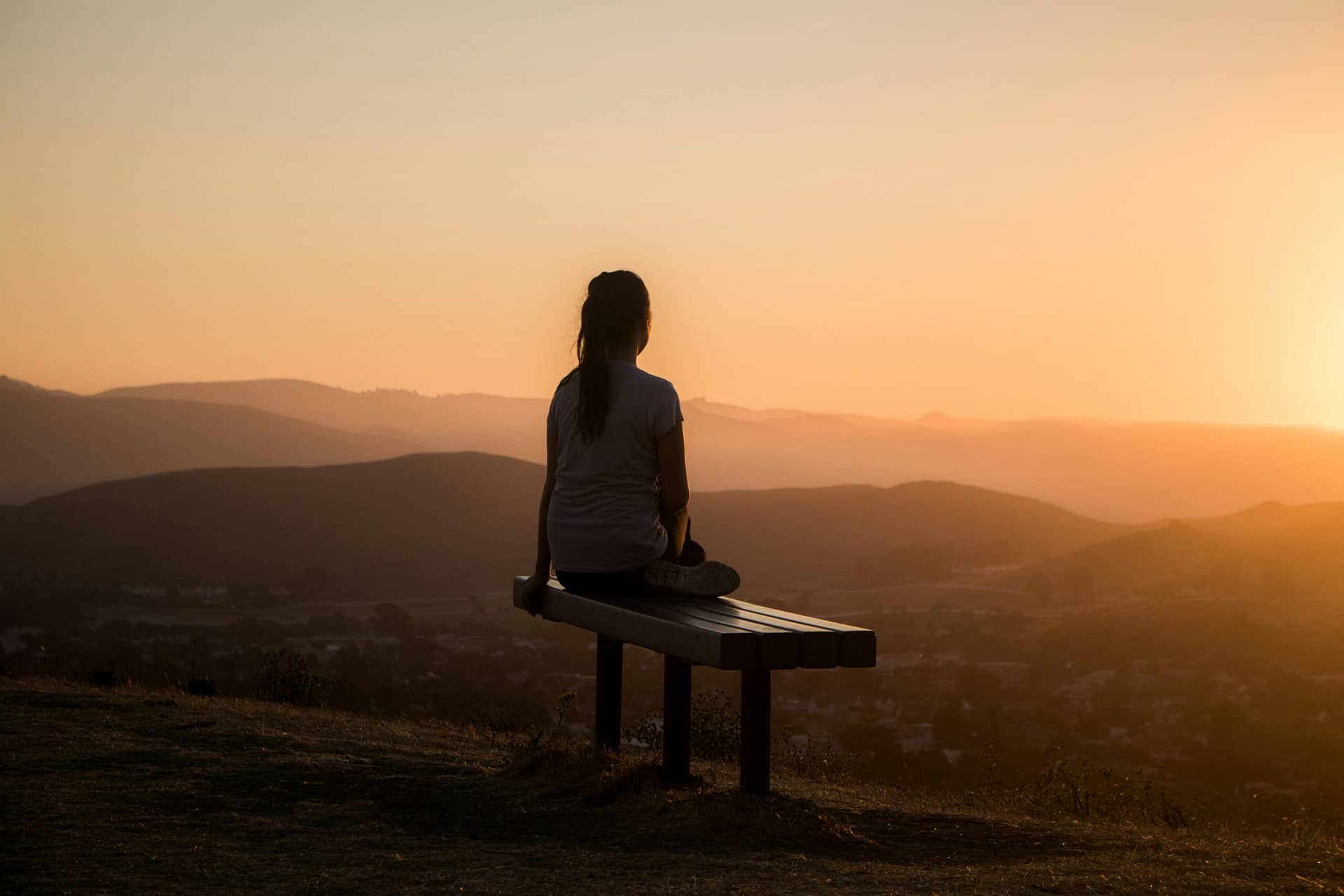 Alt="a woman sitting in deep thought wondering why is God silent"